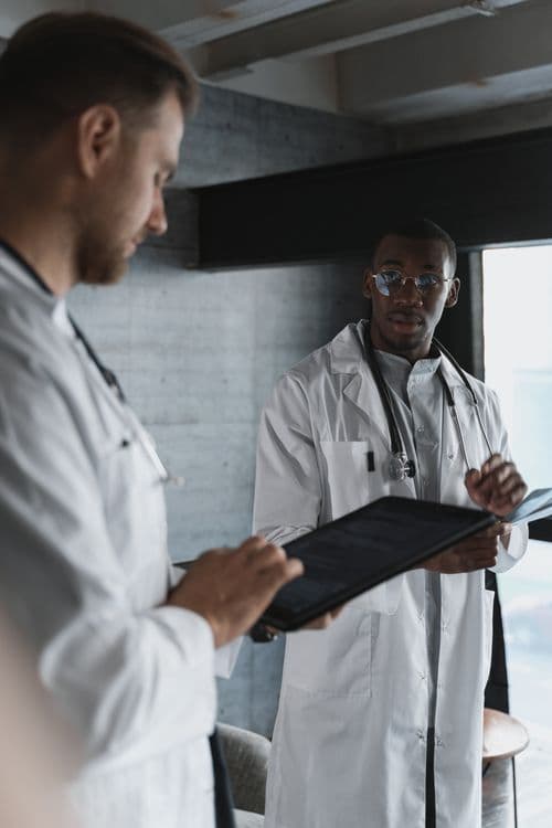 Two physicians discussing information on a tablet